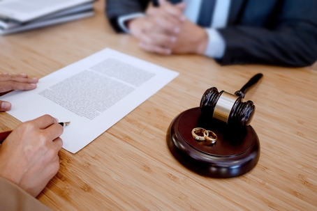 person signing divorce papers in lawyer's office